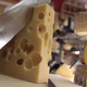 Person cutting into large slab of Swiss cheese